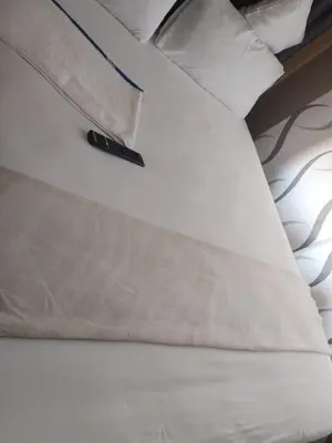 a remote control sitting on top of a bed at Queen Guest House in Pretoria