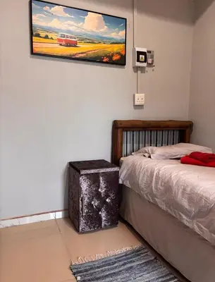a room with two beds and a tv on the wall at 54 River Logde in Mokopane