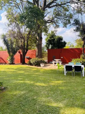 a yard with tables and chairs in the grass at 54 River Logde in Mokopane