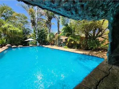 a swimming pool with blue water in a yard at Mukurumanzi Lodge in Polokwane
