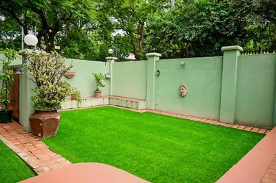 a garden with a green fence and green grass at CasaRegalo180 in Pretoria