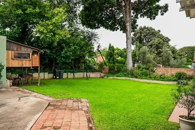 a backyard with a grass yard with a house at CasaRegalo180 in Pretoria