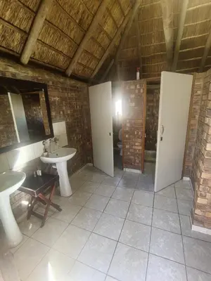 a bathroom with two sinks and a toilet at Aloe Bush Game Lodge in Marble Hall