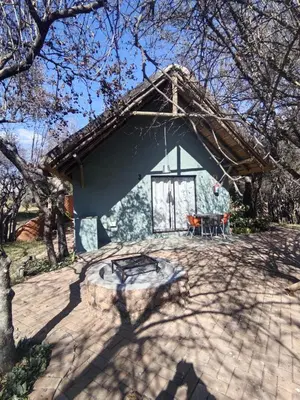 a small house with a picnic table in front of it at Aloe Bush Game Lodge in Marble Hall