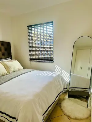 a bedroom with a large bed and a mirror at BKM Retreat Lake View in Pretoria