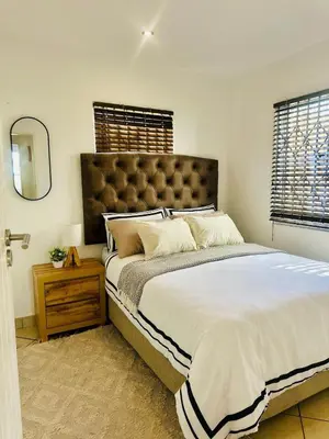 a bedroom with a large bed and a mirror at BKM Retreat Lake View in Pretoria