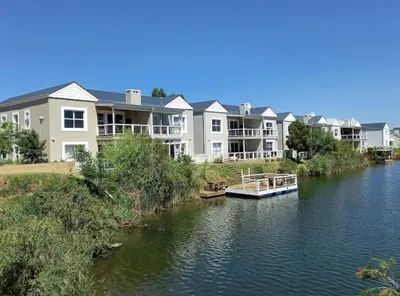a boat on a river in front of houses at BKM Retreat Lake View in Pretoria
