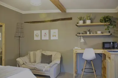 a bedroom with a couch and a chair and a desk at StayFit 06 in Polokwane