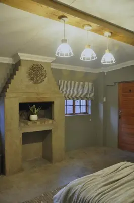 a bedroom with a fireplace and three pendant lights at StayFit 06 in Polokwane