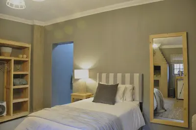 a bedroom with a bed and a mirror at StayFit 06 in Polokwane
