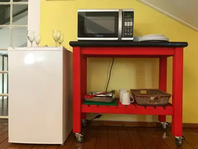 a microwave on a red cart next to a refrigerator at Diggersrest Lodge in Haenertsburg