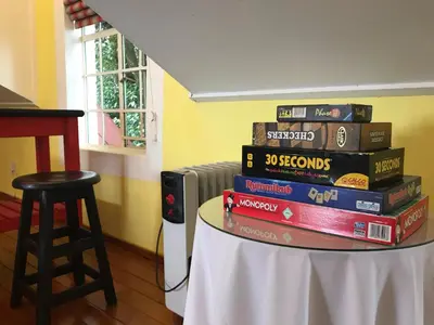 a stack of books on a table with a stool at Diggersrest Lodge in Haenertsburg