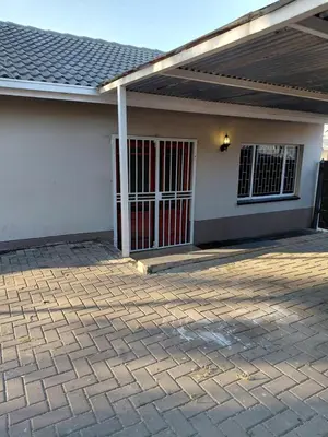 a house with a red door and a brick patio at Shalom self catering Cottage in Centurion
