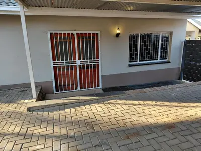 a front door of a house with a red gate at Shalom self catering Cottage in Centurion