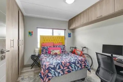 a bedroom with a bed and a desk and a bike at 231 Whisken Ave, Crowthorne Ah in Midrand