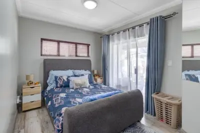 a bedroom with a bed and a chair and a window at 231 Whisken Ave, Crowthorne Ah in Midrand