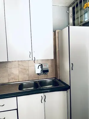 a kitchen with white cabinets and a sink at Cloud 10 Hideaway in Pretoria