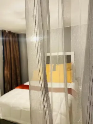 a bedroom with a bed and a curtain at Cloud 10 Hideaway in Pretoria