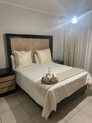 a bedroom with a large white bed with a tray on it at The Blyde Crystal lagoon 3-bed entire apartment in Pretoria
