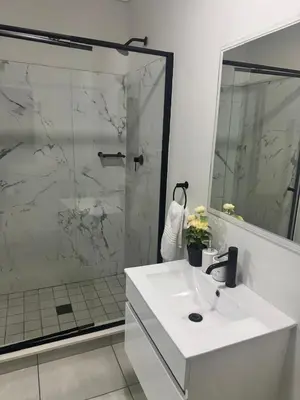 a bathroom with a white sink and a shower at The Blyde Crystal lagoon 3-bed entire apartment in Pretoria
