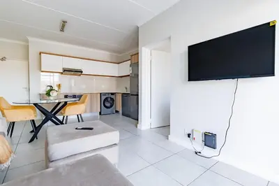 a living room with a couch and a tv on a wall at Crystal Lagoon lifestyle holiday in Pretoria