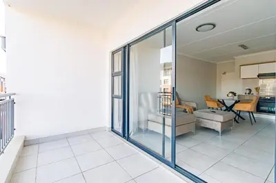 a living room with glass doors and a couch at Crystal Lagoon lifestyle holiday in Pretoria