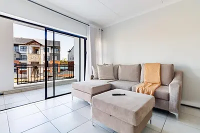 a living room with a couch and a large window at Crystal Lagoon lifestyle holiday in Pretoria