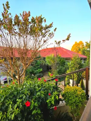 a house with a red roof and some flowers at The Garden on Hartbeespoort in Hartbeespoort