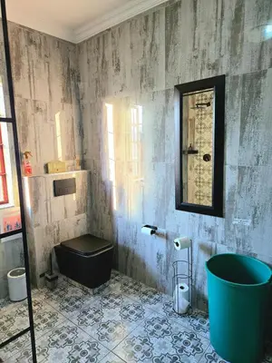 a bathroom with a tub and a toilet and a mirror at The Garden on Hartbeespoort in Hartbeespoort