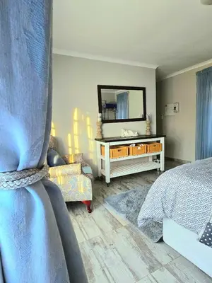 a bedroom with a bed and a dresser with a mirror at The Garden on Hartbeespoort in Hartbeespoort