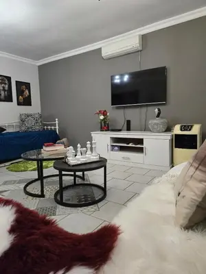a living room with a couch and a tv at The Garden on Hartbeespoort in Hartbeespoort
