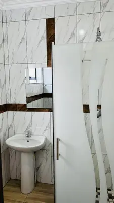 a white bathroom with a sink and a white sink at De Mose Family Lodge in KwaZibukwane