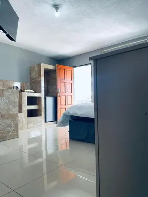 a bedroom with a bed and a door in a room at De Mose Family Lodge in KwaZibukwane