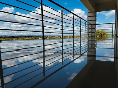 a room with a view of the water through the window at De Mose Family Lodge in KwaZibukwane