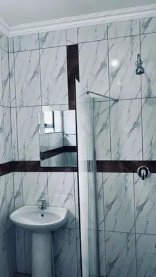 a bathroom with a sink and a glass shower at De Mose Family Lodge in KwaZibukwane