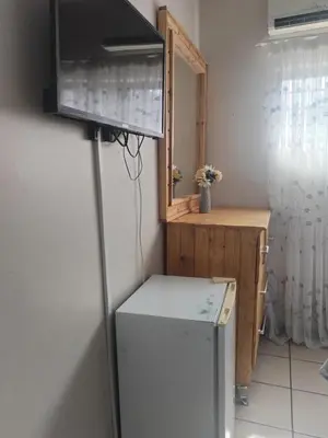 a kitchen with a refrigerator and a television on a wall at Wampi guesthouse in Polokwane
