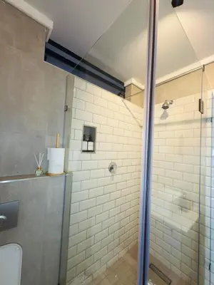 a bathroom with a shower with a glass door at Menlyn Luxe Stay 1BR, Free Parking in Pretoria