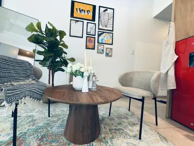 a room with a table with flowers and a bed at Menlyn Luxe Stay 1BR, Free Parking in Pretoria