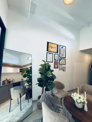 a living room with a table and chairs and a plant at Menlyn Luxe Stay 1BR, Free Parking in Pretoria