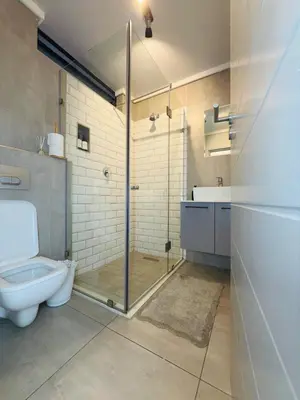 a bathroom with a shower and a toilet and a sink at Menlyn Luxe Stay 1BR, Free Parking in Pretoria
