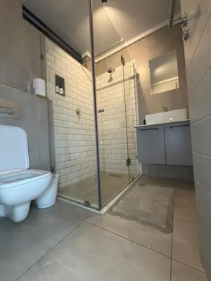 a bathroom with a shower and a toilet and a sink at Menlyn Luxe Stay 1BR, Free Parking in Pretoria