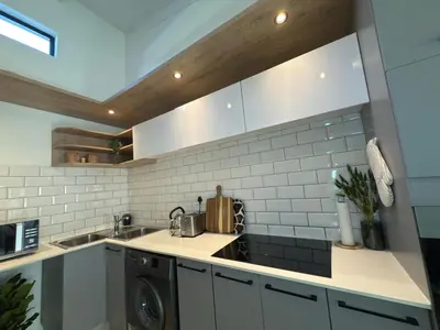 a kitchen with a sink and a washing machine at Menlyn Luxe Stay 1BR, Free Parking in Pretoria