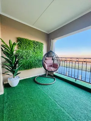 a room with a swinging chair on a balcony at Luxury Lakeview Stay With Workspace in Midrand