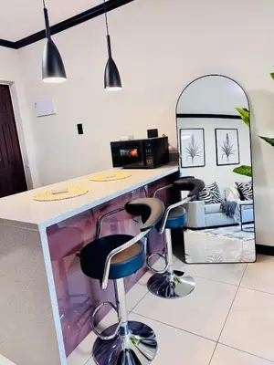 a kitchen with a counter with three stools at Luxury Lakeview Stay With Workspace in Midrand