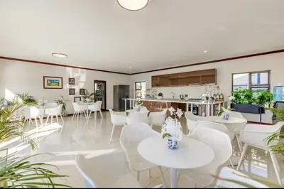 a dining room with white tables and white chairs at Luxury Lakeview Stay With Workspace in Midrand