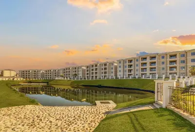 a large apartment building with a pond in front of it at Luxury Lakeview Stay With Workspace in Midrand
