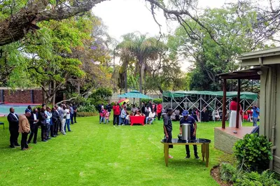 a crowd of people standing around in a park at No 24 Allan Road in Midrand
