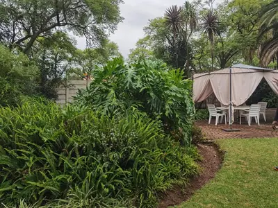 a table and chairs in a yard with a tent at No 24 Allan Road in Midrand