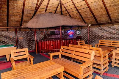 a restaurant with wooden benches and an umbrella at No 24 Allan Road in Midrand