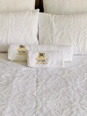 a white bed with two white pillows on it at Mulwela Palace & Resort in Sigande